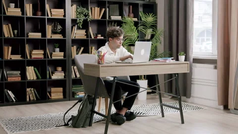 Focused and concentrated student preparing for classes in a modern library. Boy Stock Footage 316422181