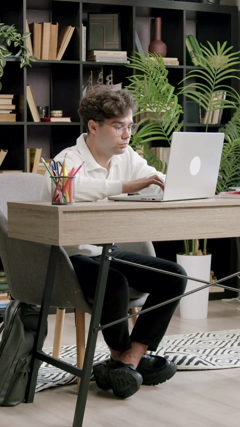 Focused and concentrated student preparing for classes in a modern library. Boy Stock Footage 316605967