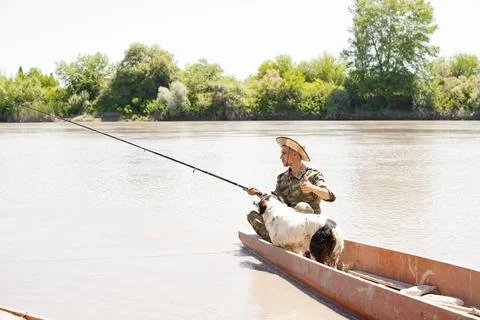 Focused angler showing thumb up, while sitting on stern boats, fishing and Stock Photos