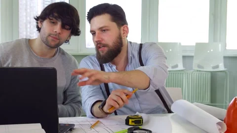 Focused architects collaborating over a laptop Stock Footage 311985553