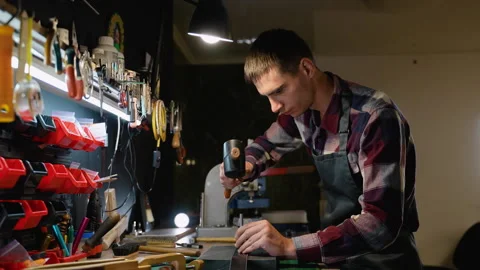 Focused Artisan Creating a Leather Belt in a Tool-Filled Workshop Stock Footage 296347989