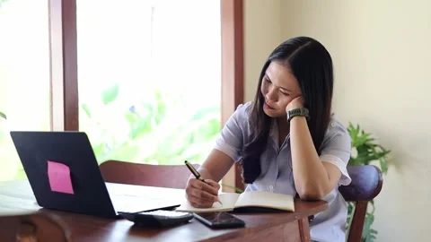 Focused Asian college student making notes writing down information from book Vídeo Stock 342489817