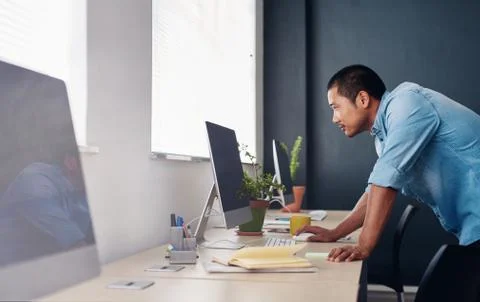 Focused Asian designer working on a computer in an office Stock Photos