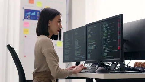 Focused Asian Female Programmer Coding on Multiple Monitors. Stock Footage 300245909