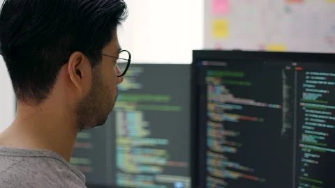 Focused Asian Male Programmer Coding on Multiple Monitors in Modern Office. Stock Footage 310589357