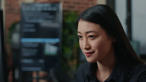 Focused asian software developer writing programming code and smiling sitting at 스톡 동영상 168242816