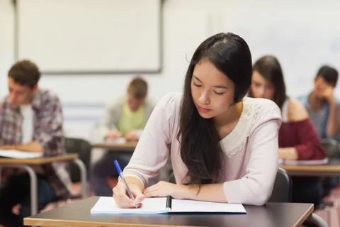 Focused asian student taking notes in class Fotos Stock