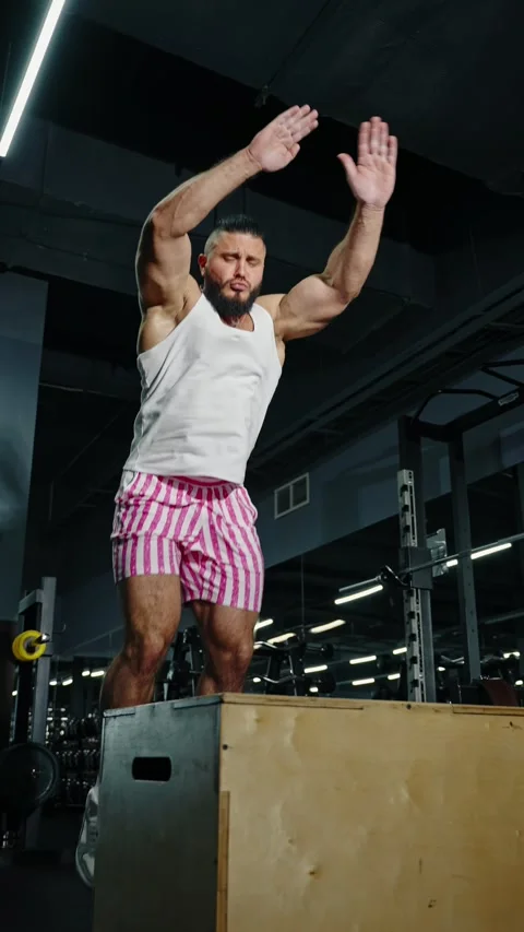 Focused athlete performing explosive box jumps in a modern indoor gym 스톡 동영상 329557626