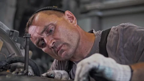 Focused automotive engineer performs maintenance and overhaul of engine Stock Footage 261288820
