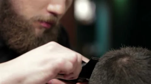 Focused barber skillfully grooming a bearded man in a stylish barbershop Stock Footage 311657126