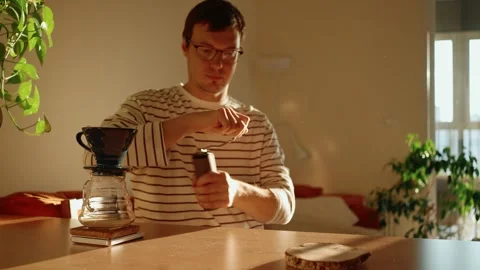 Focused barista grinding roasted coffee beans with a manual coffee grinder for 動画素材 346278420