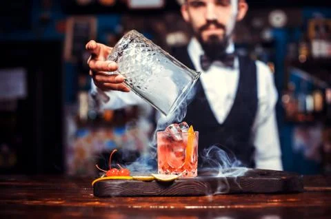 Focused bartender demonstrates the process of making a cocktail Foto stock