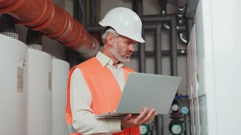 Focused bearded specialist with modern computer checking machines at plant room 스톡 동영상 255102635