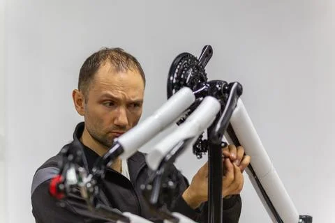 Focused bicycle mechanic assembling a new bike frame in a workshop Stock Photos
