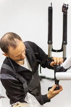 Focused bicycle mechanic assembling a new bike frame in a workshop Stock Photos