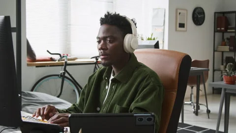 Focused Black Male Programmer Writing Code for Mobile App Stockbeeldmateriaal 335937319