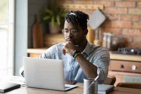 Focused black male read web search result on laptop screen Stock Photos