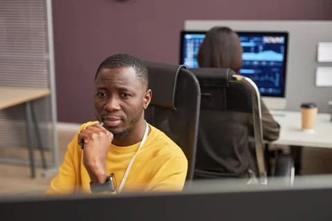 Focused black man looking at computer screen in office Stock Photos