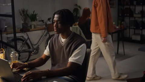 Focused Black Man Working on Laptop Overtime in Creative Office Stock Footage 338416425