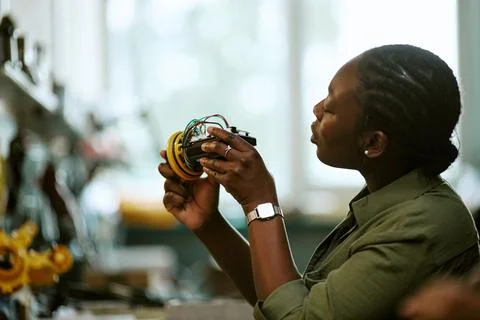 Focused Black Woman Engineer Inspecting Robotics Prototype Stock Photos