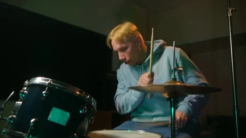 Focused blond drummer playing dynamic drums, musician immersed rhythmic music Stock Footage 312846220