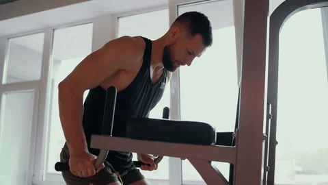 The focused bodybuilder performs lifts with his hands positioned in parts on the Stock Footage 156471504