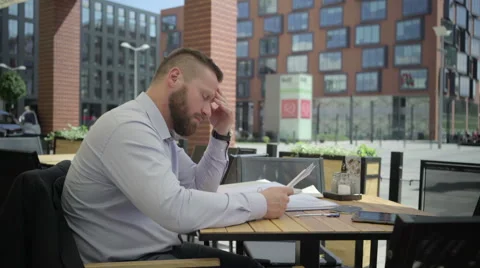 Focused busienssman reading documents, in cafe, steadicam. Vídeo Stock 66334203