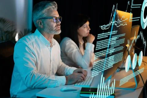 Focused Business Professionals Analyzing Data on Futuristic Computer Screens Stock Photos