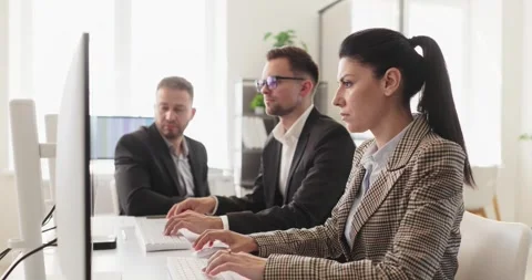 Focused business team of analysts collaborating at computers in modern office Stock Footage 344747686
