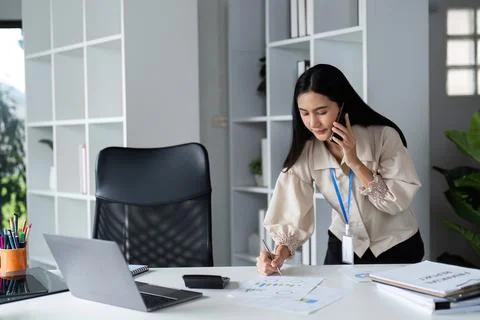 Focused Businessman Analyzing Documents at Modern Office Desk with Laptop and Foto stock