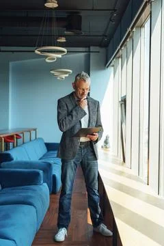Focused businessman looking on documents and think how to solve problem while Stock Photos