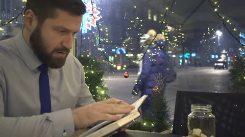 Focused businessman make notes, cafe, evening, city, slider shot 動画素材 72999508