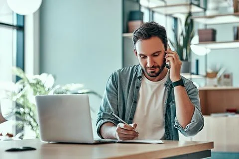 Focused businessman making notes in notebook at cafe Stock Photos
