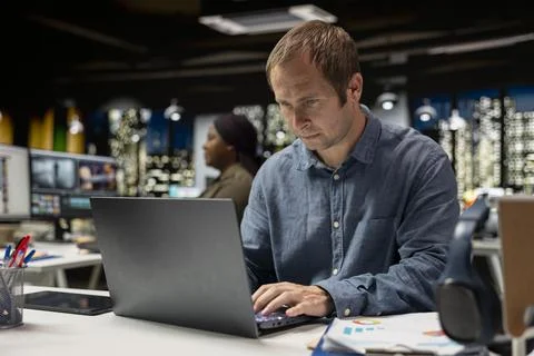 Focused businessman using computer to analyze insights and performance metrics 库存照片