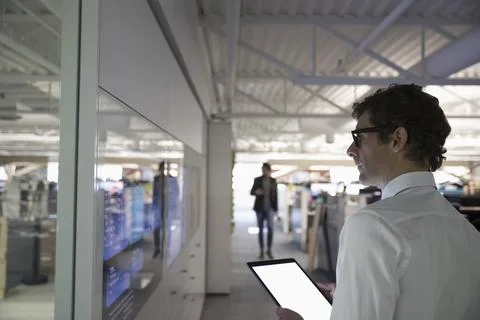 Focused businessman using digital tablet at screen in office Stock Photos