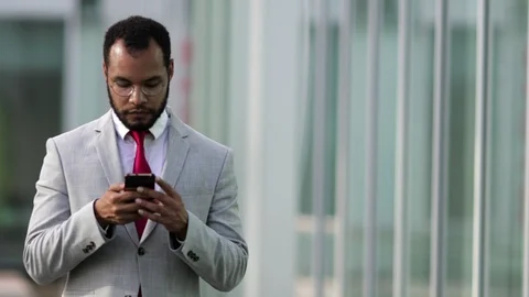 Focused businessman using smartphone during stroll Stock-Footage 114963526