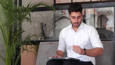 Focused businessman waiting for interview using laptop. Stockbeeldmateriaal 146204443