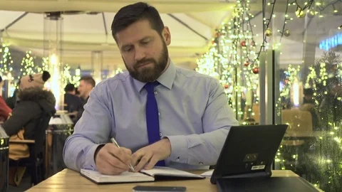Focused businessman work with notes, tablet, look at camera, cafe, evening Vidéo 73000740