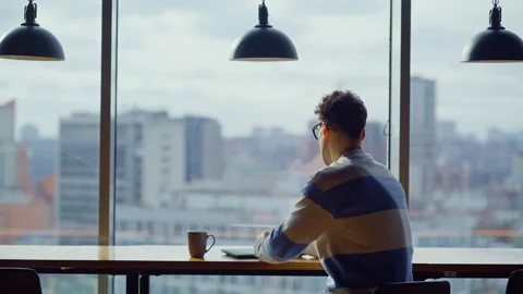 Focused businessman working laptop computer pondering in large windows office Stock Footage 335247410