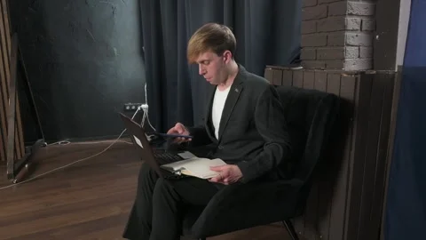 Focused Businessman Working Remotely with Laptop and Smartphone in a Office Stock Footage 345209728