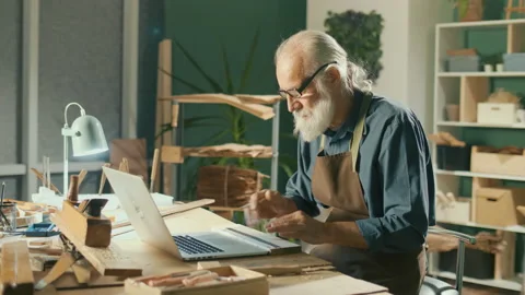 A Focused Carpenter Develops Layouts from Wood Models 3D Sketches Using a Laptop 動画素材 170912069