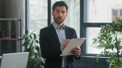 Focused caucasian businessman developer with paper tablet write notes data in Stock Footage 254093788
