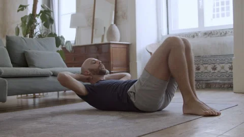 Focused Caucasian man exercising abs on floor at home Stock Footage 229634928