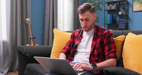 Focused Caucasian man using laptop at home, looking at screen, chatting, reading Stockbeeldmateriaal 154045735