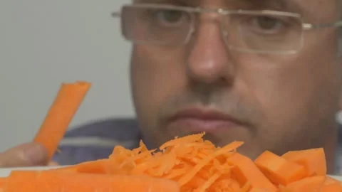 A Focused Chef Skillfully Preparing Fresh and Vibrant Carrots for a Culinary Видео 282582168