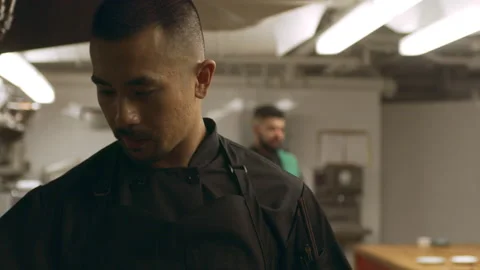 Focused chef stirring pot of boiling vegetables over stovetop with a spoon in in Video stock 199455257