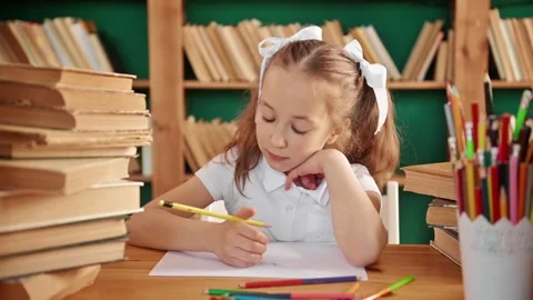 A focused child is engaged in the library. Blond white girl with ponytails 8-10 Video stock 195011863