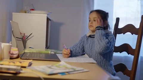 A Focused Child Engaged in Online Learning Activities at Home with Resources and Stock Footage 308461678