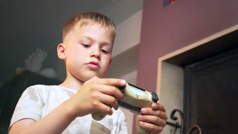 Focused Child Learning to Play Video Games at Home. Small Boy Holding controller Stock Footage 133769626