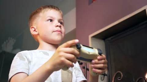 Focused Child Learning to Play Video Games at Home. Small Boy Holding controller Stock Footage 133769923